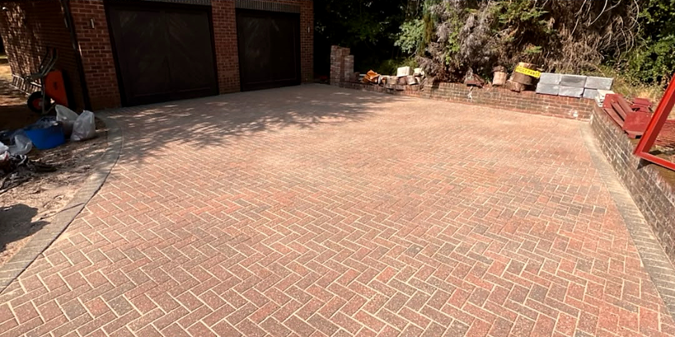 Herringbone block paved garage forecourt cleaned — after